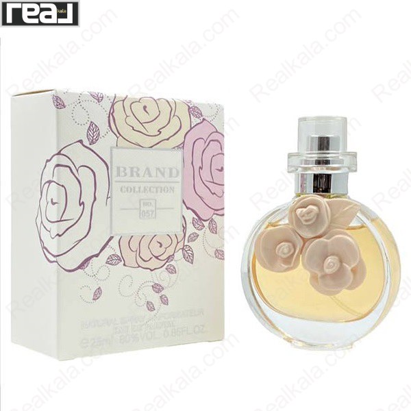 شیشه و جعبه ادکلن برند کالکشن 057 با یقه فلزی، درپوش شفاف و گل‌های کرم‌رنگ تزئینی روی بطری
