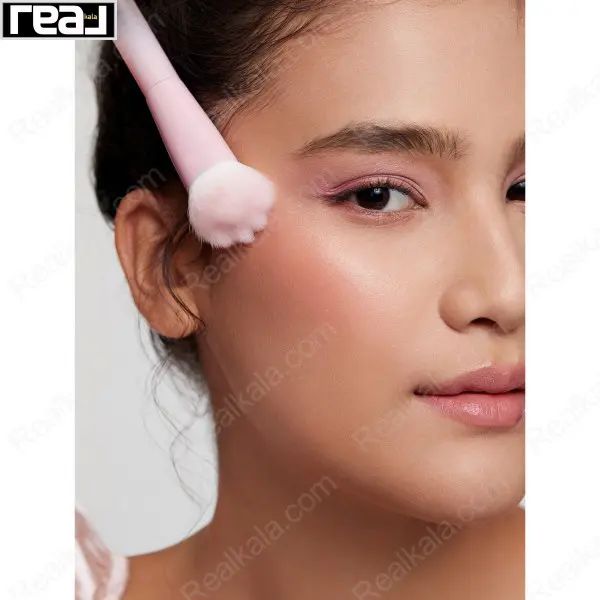 مدل در حال استفاده از براش صورتی Sheglam برای پخش رژگونه روی گونه‌ها